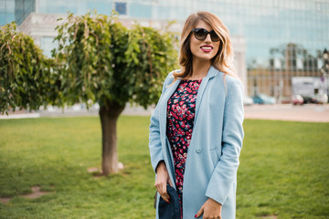 Happy girl in stylish wear walking by park