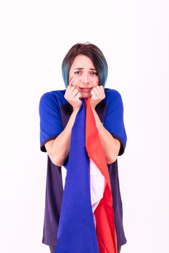 Portrait d'une jeune supportrice de l'équipe de France de football, le drapeau national dans ses mains