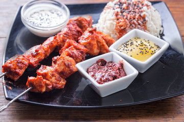 Chicken tandoori skewers with rice and sauces