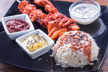 Chicken tandoori skewers with rice and sauces