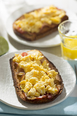 Sourdough bread slices with fried bacon and scrambled eggs 