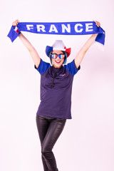 Portrait d'une jeune supportrice de l'équipe de France de football portant un chapeau , des lunettes tricolore et une écharpe de son équipe - obrazy, fototapety, plakaty