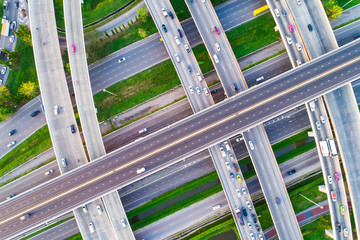 Aerial view car movement on traffic junction road with green tree park