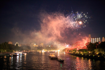 Osaka, Japan - July 25, 2015: Boats cruise up the O River during a fireworks display at the Tenjin...