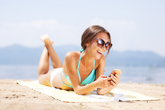 girl with smartphone on a beach