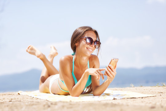 girl with smartphone on a beach