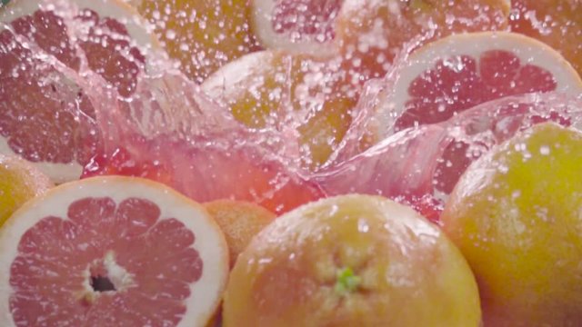Grapefruit falling in juice with splash between grapefruits. Slow motion 480 fps. Sony rx10 camera