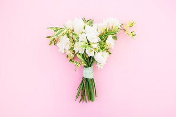 Wedding bouquet of white flowers on pink background. Flat lay, top view. Wedding composition.