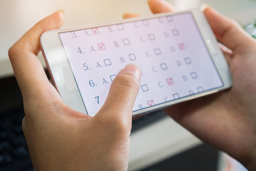 Student testing E-learning exam on tablet computer with multiple choice questions by finger clicking. Concept Educational technology use physical hardware internet for distant online learning © smolaw11