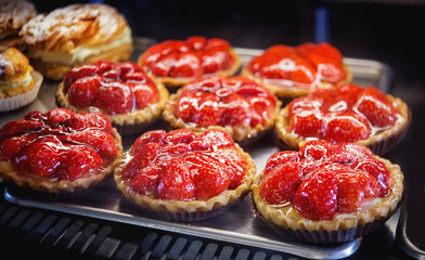 Cakes with strawberries on a metal tray