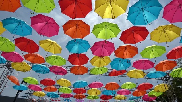 Tilt shot of the colorful umbrellas hanging in the sky
