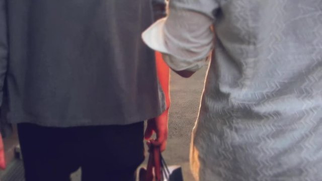 下町を歩く男性2人の後ろ姿と間から見える街並み