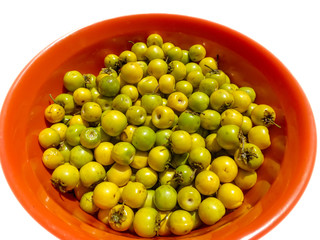 An isolated bowl of Nanche (or nance) fruit. Native to tropical America, it is sweet and strongly scented.