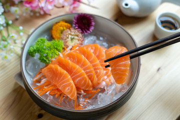 Salmon sashimi slice fresh serve on ice with tea, Japanese style