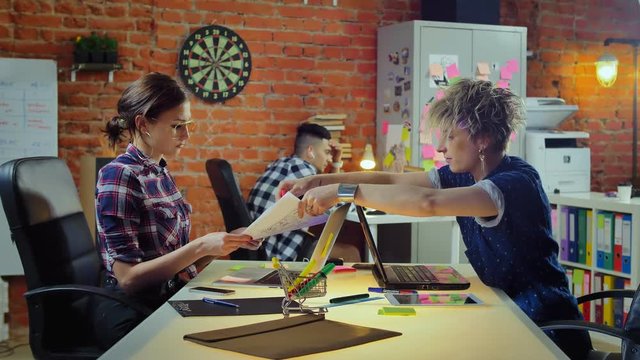 Two women screenwriters argue and throws documents in face while quarrel at office