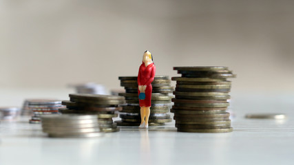 Concept of work and women. A woman standing in the middle of a pile of coins.