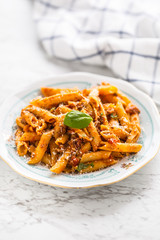 Italian food and pasta pene with bolognese sause on plate