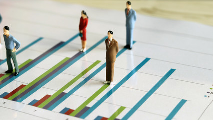 Fototapeta premium Miniature people and the graph concept. Miniature of people on a bar graph.