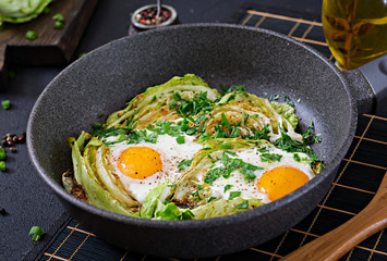 Fried eggs with slices of young cabbage and greens. Nutritious breakfast.