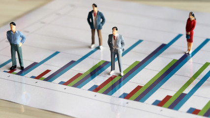 Three&nbsp;miniature&nbsp;man&nbsp;and&nbsp;one&nbsp;miniature&nbsp;woman&nbsp;on&nbsp;the&nbsp;bar&nbsp;graph.