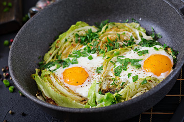 Fried eggs with slices of young cabbage and greens. Nutritious breakfast.
