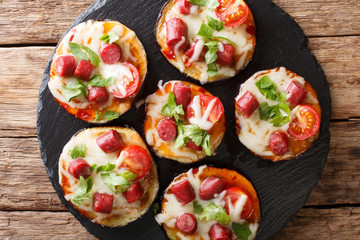 Appetizing of baked eggplant with cheese, tomatoes, sausages close-up. horizontal top view