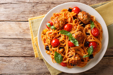 Homemade meat balls with spaghetti, aubergines and tomatoes close-up. horizontal top view