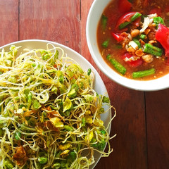 fried sunflower sprout with papaya salad sauce on wooden table