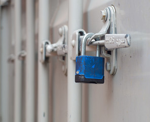 Blue padlock on white shipping container door