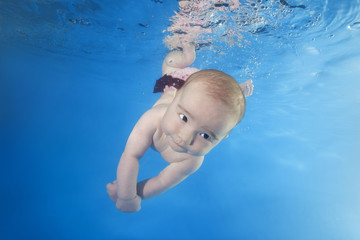 little girl learns to swim the underwater in the pool