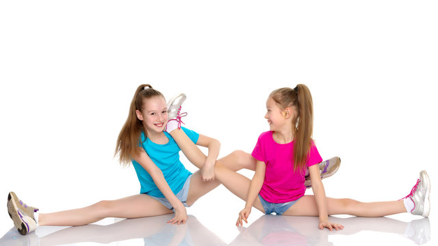 Girls gymnasts perform exercises on twine.