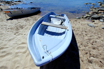 Dwie łódki wyciągnięte na piaszczystą plaże na wybrzeżu Bałtyku - obrazy, fototapety, plakaty