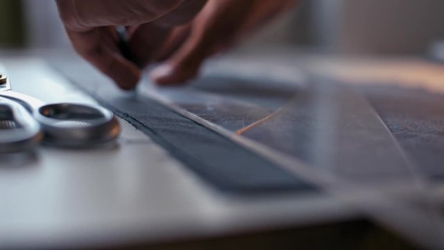 ClosUp to Tailor Hands Making a Pattern on the Fabric before Sew Fashionable Clothes