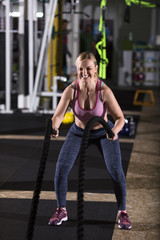 athlete woman doing battle ropes cross fitness exercise