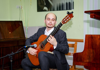 Obraz premium The guitarist performs a piece of music and puts his soul into it.