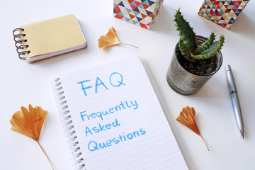FAQ Frequently Asked Questions written in notebook on white table