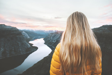 Blonde hair woman alone in sunset mountains adventure lifestyle vacations weekend getaway aerial Norway lake landscape