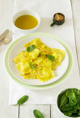 Ravioli with ricotta and spinach, served with olive oil and pine nuts. Rustic style.
