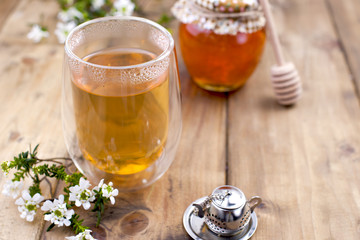 tea with herbs and honey on a wooden background and flowers. Natural health. Copy cpace.