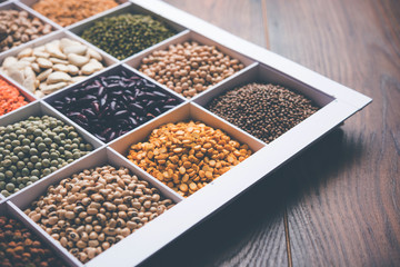 Indian Beans,Pulses,Lentils,Rice and Wheat grain in a white wooden box with cells, selective focus.