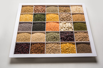 Indian Beans,Pulses,Lentils,Rice and Wheat grain in a white wooden box with cells, selective focus.
