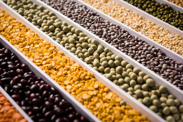 Indian Beans,Pulses,Lentils,Rice and Wheat grain in a white box with cells or strips, selective focus.