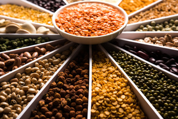 Indian Beans,Pulses,Lentils,Rice and Wheat grain in a white Sunburst or sun rays shape designer container , selective focus.