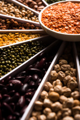 Indian Beans,Pulses,Lentils,Rice and Wheat grain in a white Sunburst or sun rays shape designer container , selective focus.