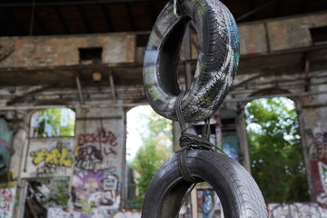 Naklejka premium Hanging tires at the old abandoned train repair factory (Reichsbahnausbesserungswerk / altes Bahnhofsgebäude) in Leipzig, Germany