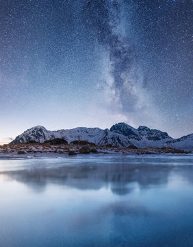Night sky and reflection on the frozen lake. Natural landscape in the Norway