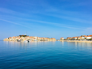 Fototapeta na wymiar The town of Primosten across the blue ocean, Croatia