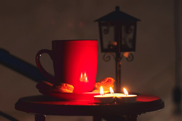 Cup of brewed coffee, a branch of spruce and lantern