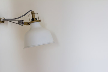 Asjustable white lamp on the wall background