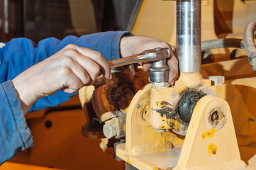Hands of mechanic working in auto repair shop.